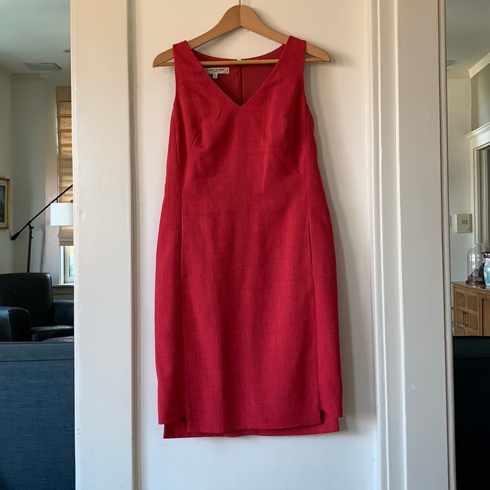 Classic sheath dress with pockets and unique hemline.